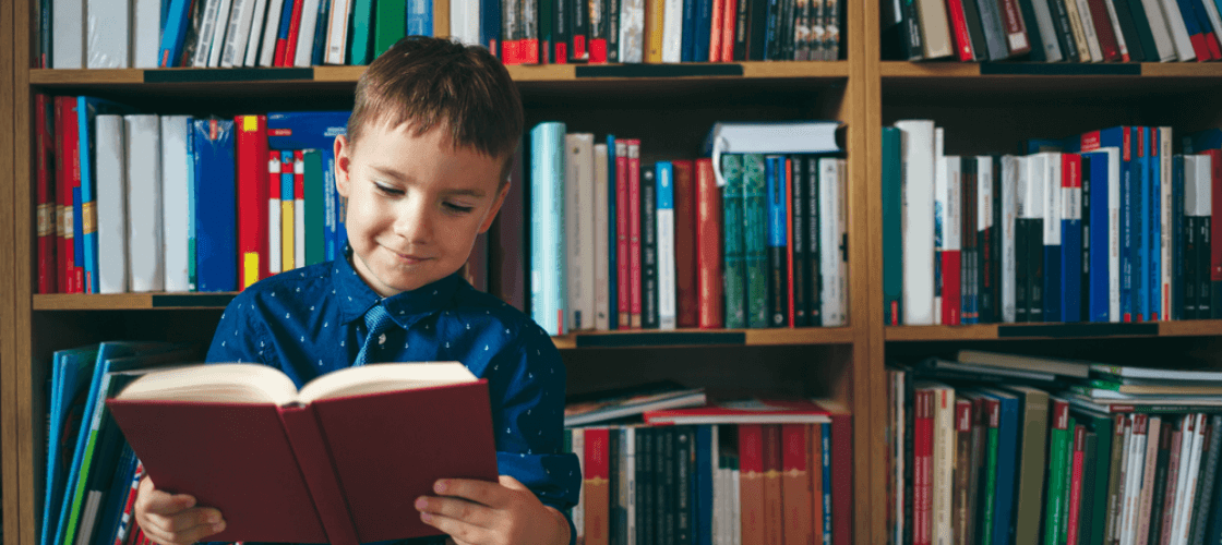 Gifted child holding a book in front of a bookshelf  prepares to take a free IQ test for children